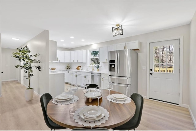 dining room with recessed lighting, baseboards, and light wood finished floors