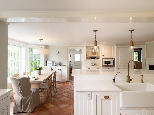11 Water St, Duxbury, MA 02332 - kitchen with a sink, white microwave, plenty of natural light, white cabinets, and crown molding