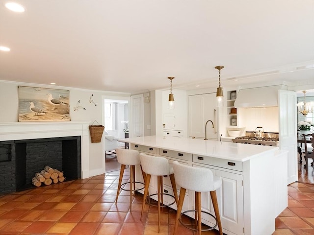 11 Water St, Duxbury, MA 02332 - kitchen featuring light countertops, an island with sink, recessed lighting, a fireplace, and a breakfast bar area