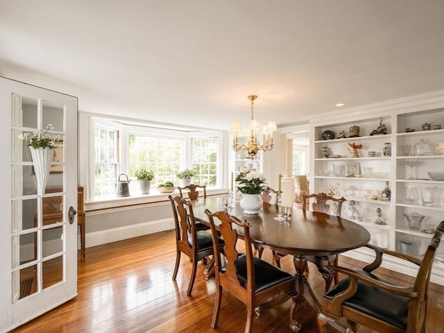 11 Water St, Duxbury, MA 02332 - dining space featuring a chandelier, wood finished floors, and baseboards