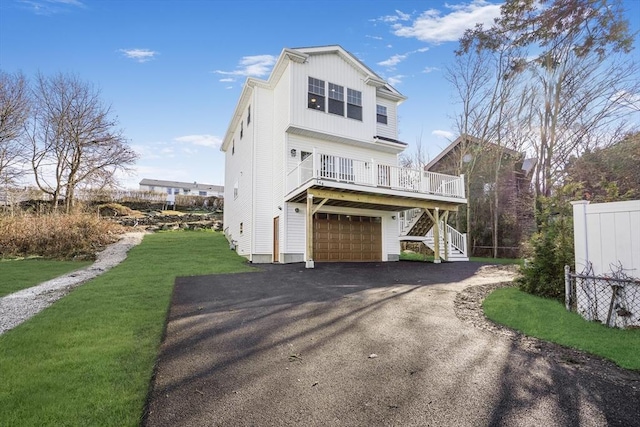 view of front facade with a garage, a wooden deck, and a front lawn