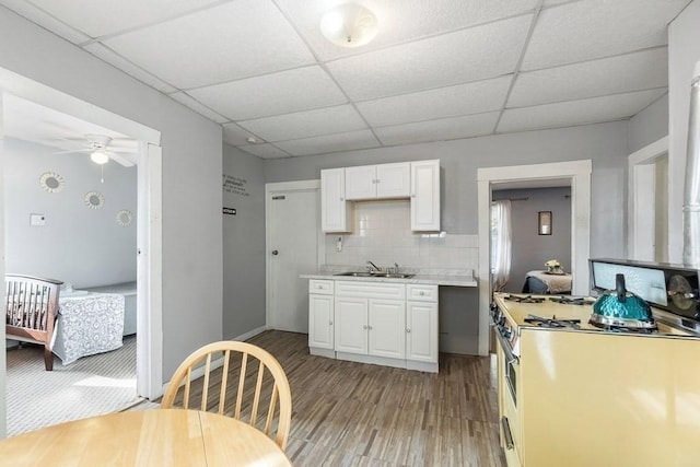14 Hancock St, Worcester, MA 01610 - kitchen featuring white gas stove, light wood-style flooring, a drop ceiling, white cabinets, and light countertops