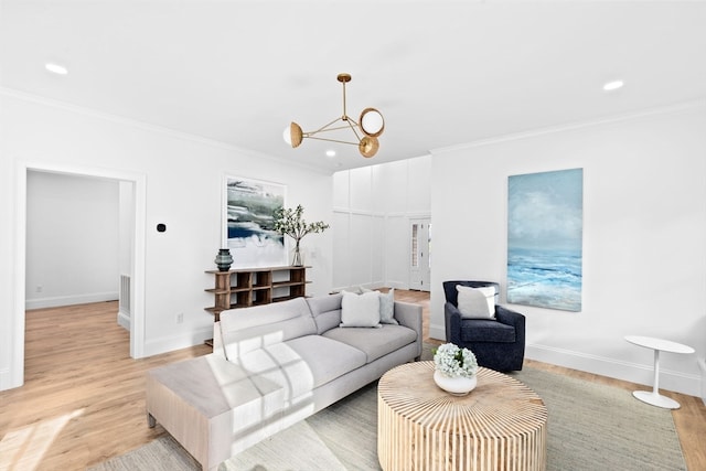 living room featuring light hardwood / wood-style floors, a notable chandelier, and ornamental molding