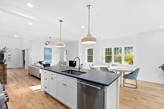 kitchen featuring sink, white cabinetry, stainless steel dishwasher, light hardwood / wood-style flooring, and a kitchen island with sink