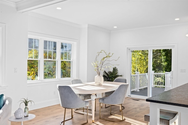 dining space with light hardwood / wood-style floors and crown molding