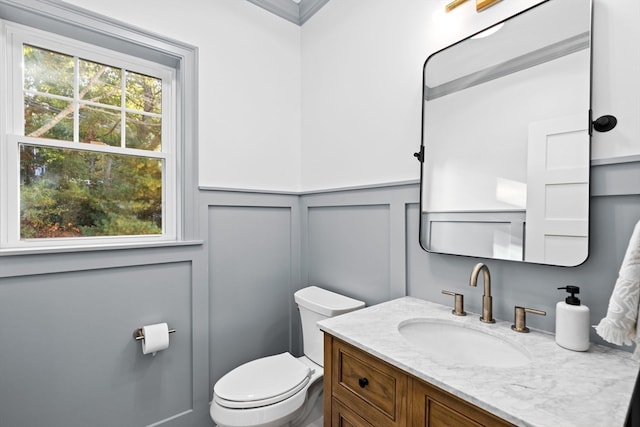 bathroom featuring vanity, ornamental molding, and toilet