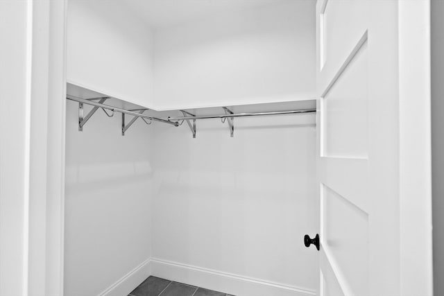 walk in closet featuring dark tile patterned flooring