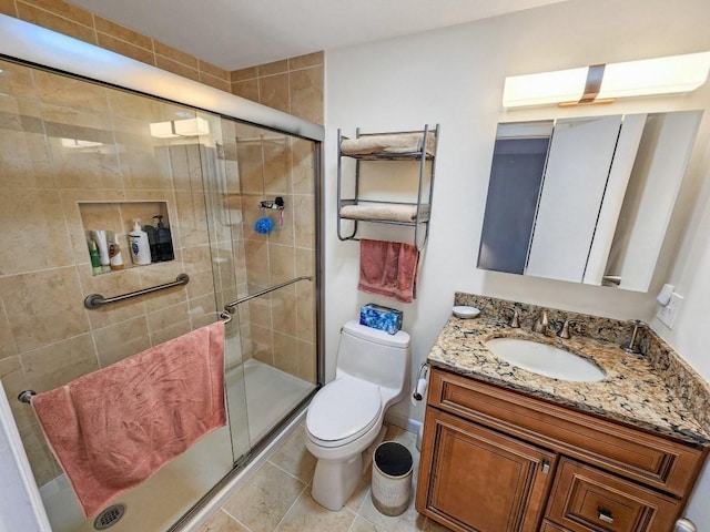 bathroom with tile patterned floors, vanity, toilet, and a shower with shower door