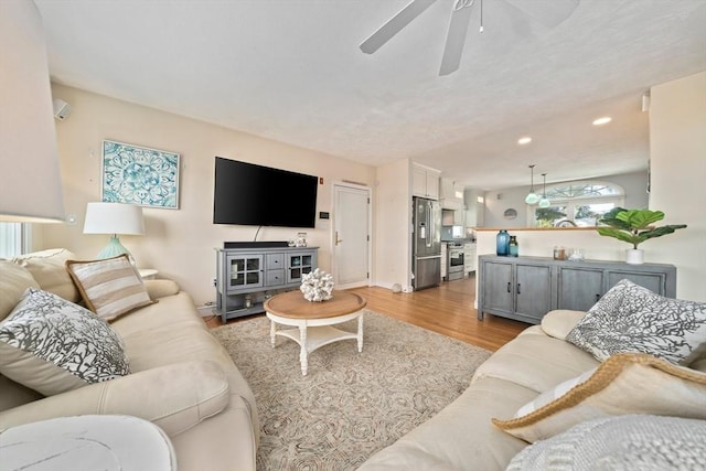 living room featuring recessed lighting, light wood-type flooring, baseboards, and ceiling fan