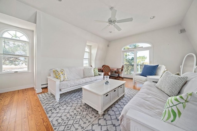 living area featuring a ceiling fan, a baseboard heating unit, recessed lighting, light wood-style floors, and baseboards