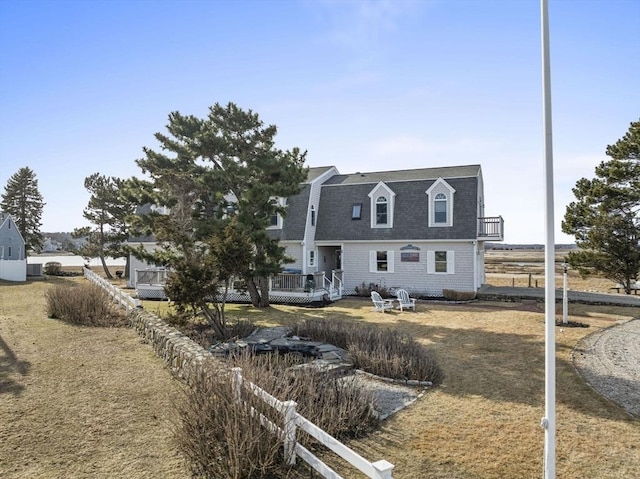 view of front of home featuring roof with shingles and fence