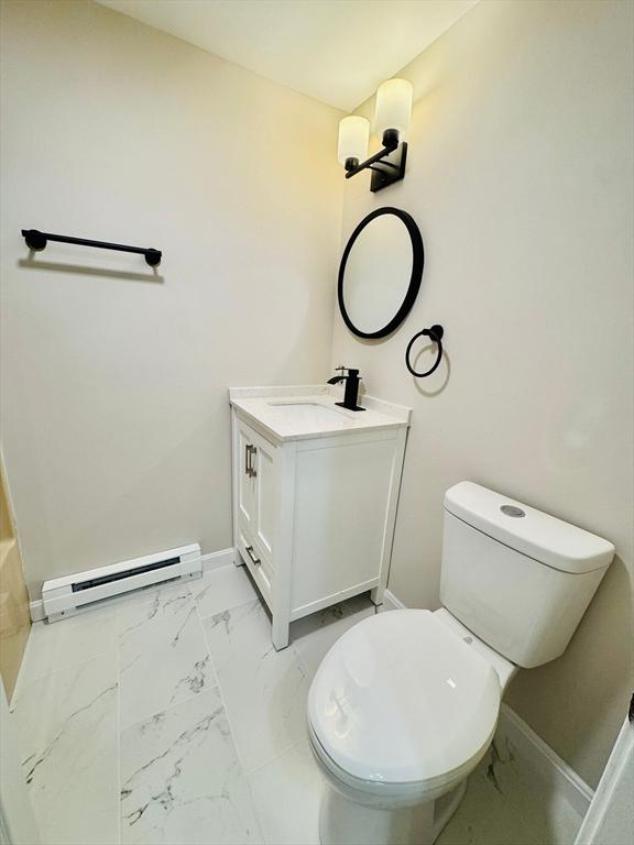 bathroom with vanity, toilet, and a baseboard heating unit