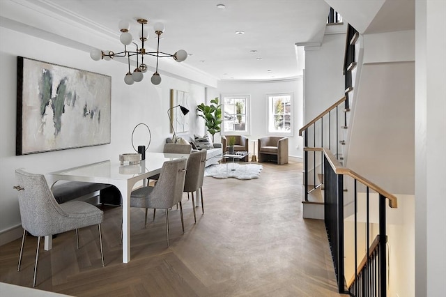 dining space with a chandelier, parquet floors, and ornamental molding