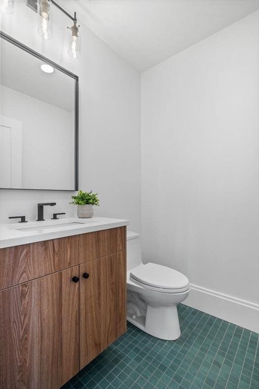 bathroom with toilet, tile patterned floors, and vanity