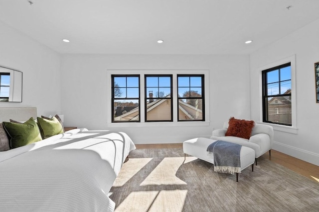 bedroom with multiple windows and light hardwood / wood-style flooring