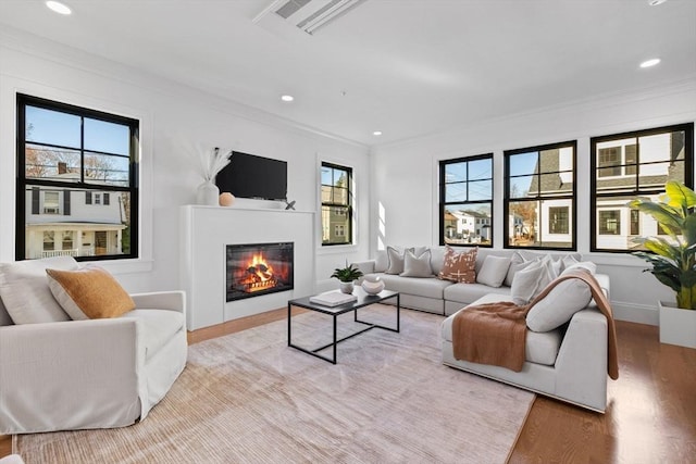 living room featuring plenty of natural light, light hardwood / wood-style flooring, and crown molding