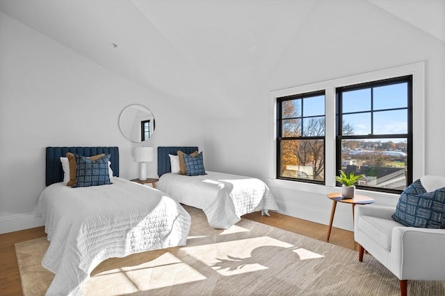 bedroom featuring lofted ceiling and light hardwood / wood-style flooring