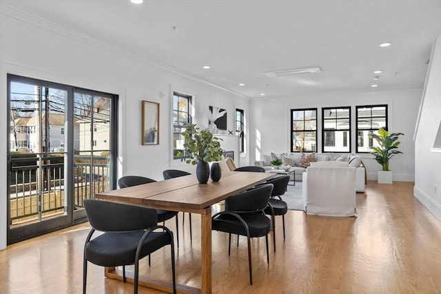 dining area with light wood-type flooring and ornamental molding