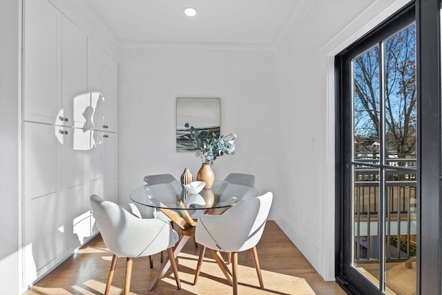 dining space with crown molding and hardwood / wood-style flooring