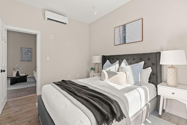 bedroom featuring a wall unit AC and wood finished floors