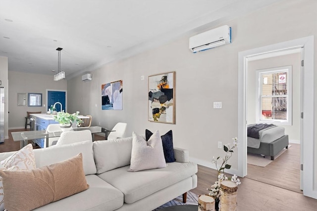 living area with a wall mounted AC, baseboards, and wood finished floors