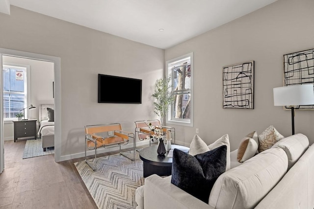 living area with light wood-type flooring and baseboards