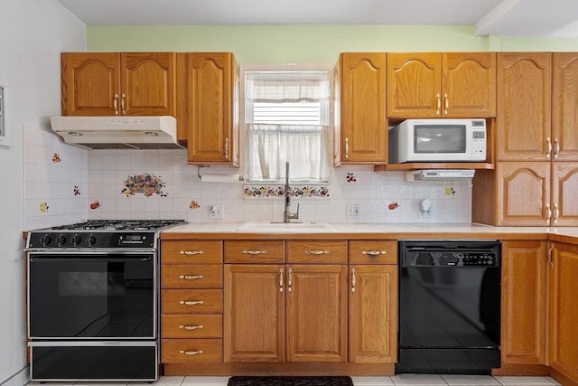 kitchen with tasteful backsplash, brown cabinets, under cabinet range hood, black appliances, and a sink