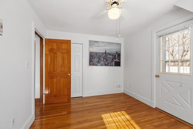 foyer entrance featuring ceiling fan, light wood-style flooring, and baseboards