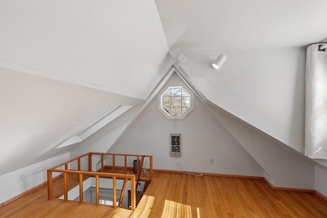 additional living space with vaulted ceiling, wood finished floors, and baseboards