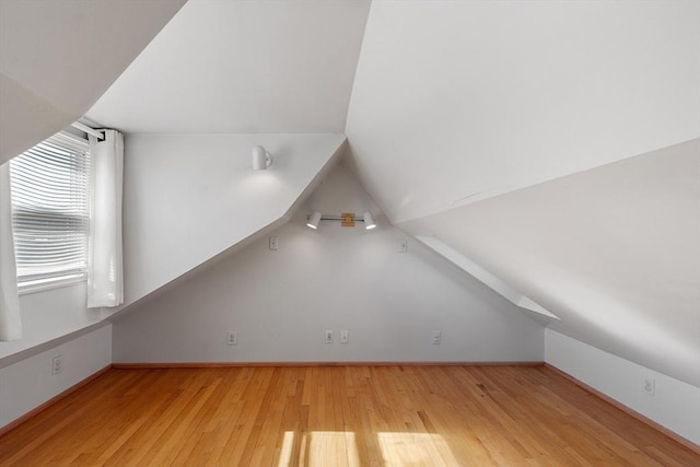 bonus room featuring vaulted ceiling, wood finished floors, and baseboards