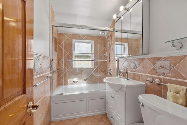 full bathroom featuring toilet, tile patterned floors, vanity, tile walls, and shower / bathing tub combination