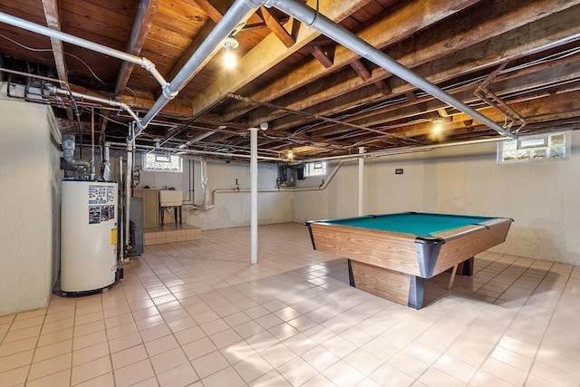 recreation room featuring a healthy amount of sunlight, water heater, and a sink