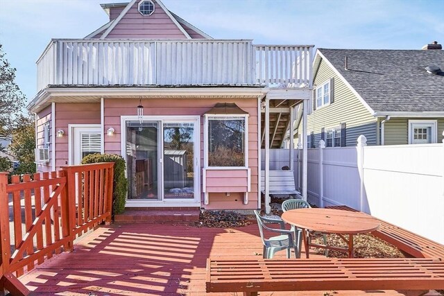 back of house with fence and a deck