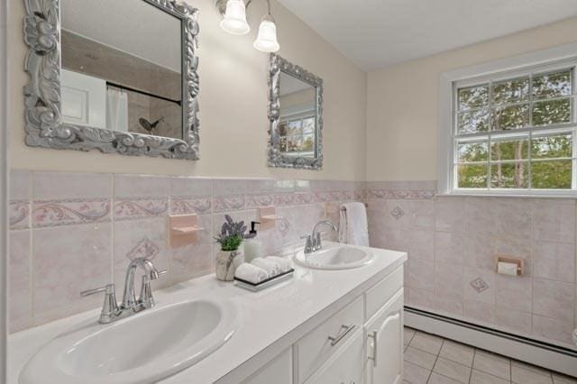 bathroom featuring double vanity, a sink, tile walls, tile patterned flooring, and a baseboard heating unit
