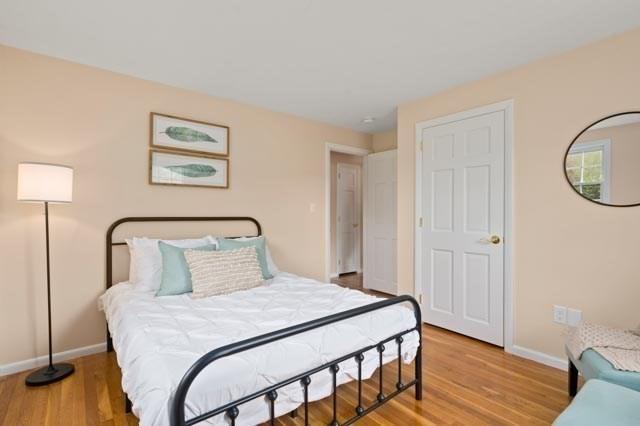 bedroom with light wood finished floors and baseboards