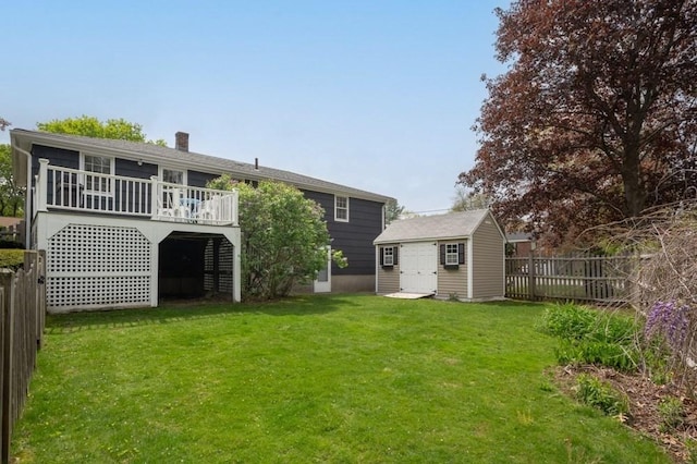 back of property featuring a storage shed, an outdoor structure, a yard, a fenced backyard, and a wooden deck