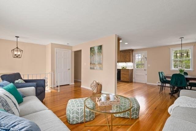 living area with baseboards, light wood finished floors, and a baseboard heating unit