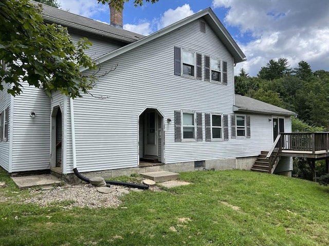 rear view of house with a yard, a chimney, and a wooden deck