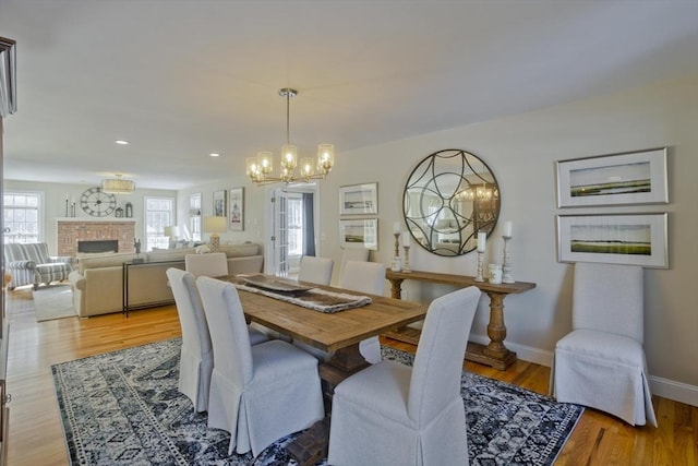 dining space featuring recessed lighting, light wood-style flooring, a fireplace, and baseboards