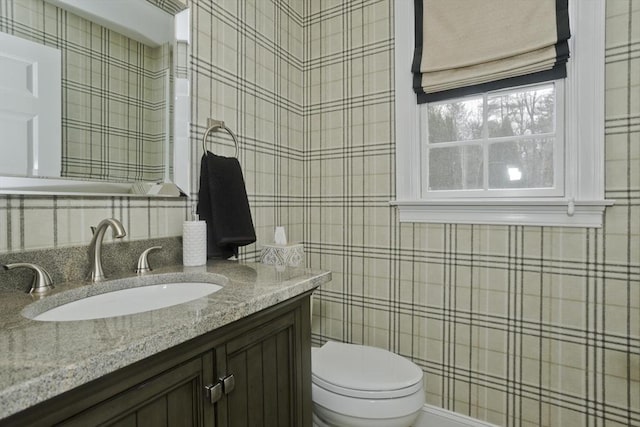 bathroom featuring toilet, tile walls, and vanity