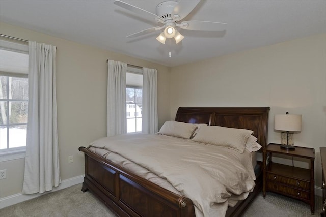 bedroom featuring light carpet, ceiling fan, and baseboards