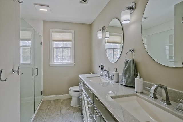 bathroom featuring a sink, baseboards, toilet, and a stall shower