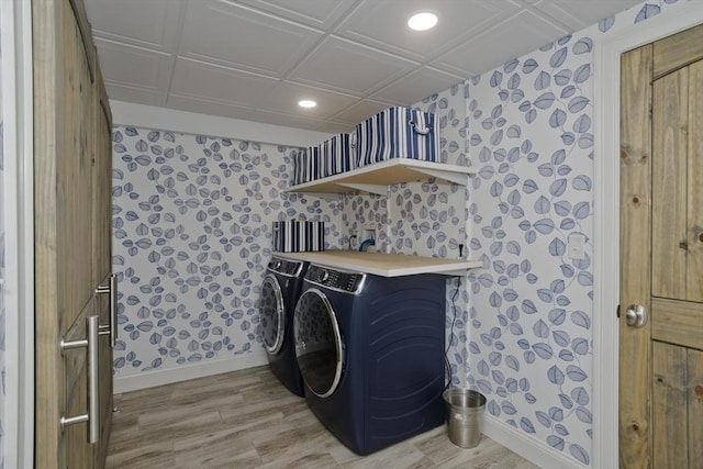 clothes washing area with washing machine and clothes dryer, laundry area, wallpapered walls, and baseboards