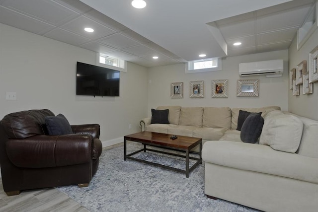 living room with an AC wall unit, recessed lighting, wood finished floors, and baseboards