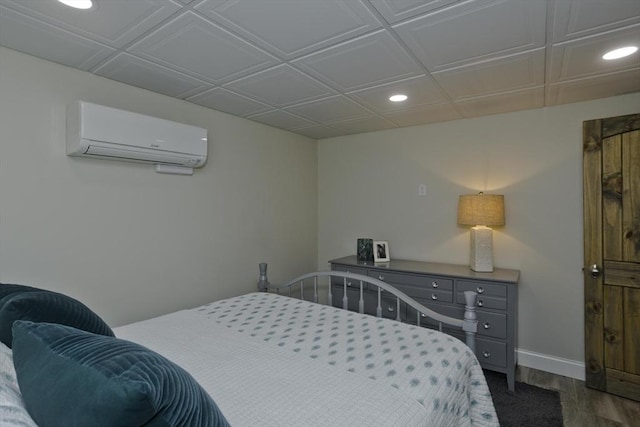 bedroom featuring recessed lighting, an AC wall unit, dark wood-type flooring, and baseboards