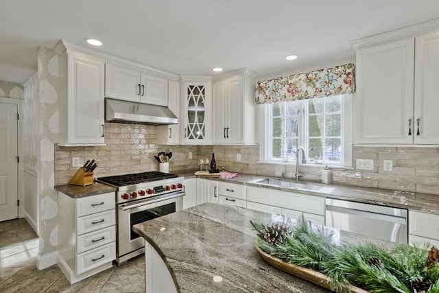 kitchen featuring dark stone countertops, white cabinets, appliances with stainless steel finishes, and under cabinet range hood