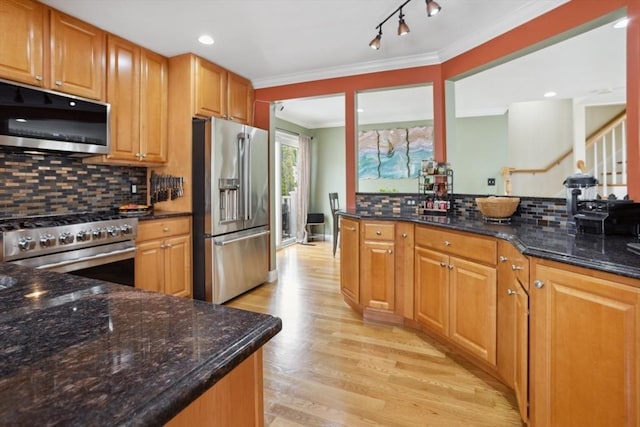 224 Grove St Unit 2, Waltham, MA 02453 - kitchen featuring appliances with stainless steel finishes, light wood-type flooring, crown molding, backsplash, and dark stone countertops