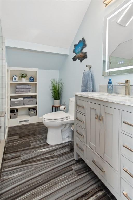224 Grove St Unit 2, Waltham, MA 02453 - bathroom featuring vaulted ceiling, vanity, wood finished floors, and a shower