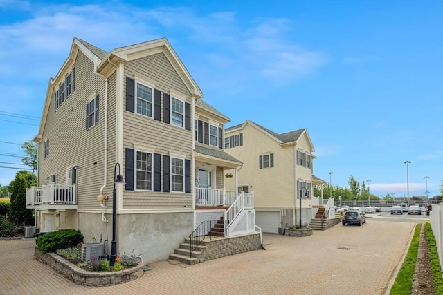 224 Grove St Unit 2, Waltham, MA 02453 - view of front of house with stairs, decorative driveway, and an attached garage