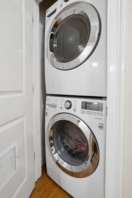 224 Grove St Unit 2, Waltham, MA 02453 - washroom featuring stacked washer / dryer and light wood-type flooring